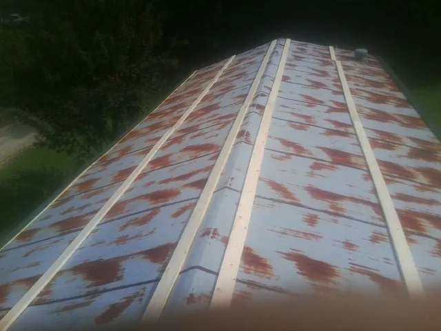 Rusted metal roof panels with new wood purlins before replacement — Storm Damage Roof Repair in Deltona by Roofing Brothers